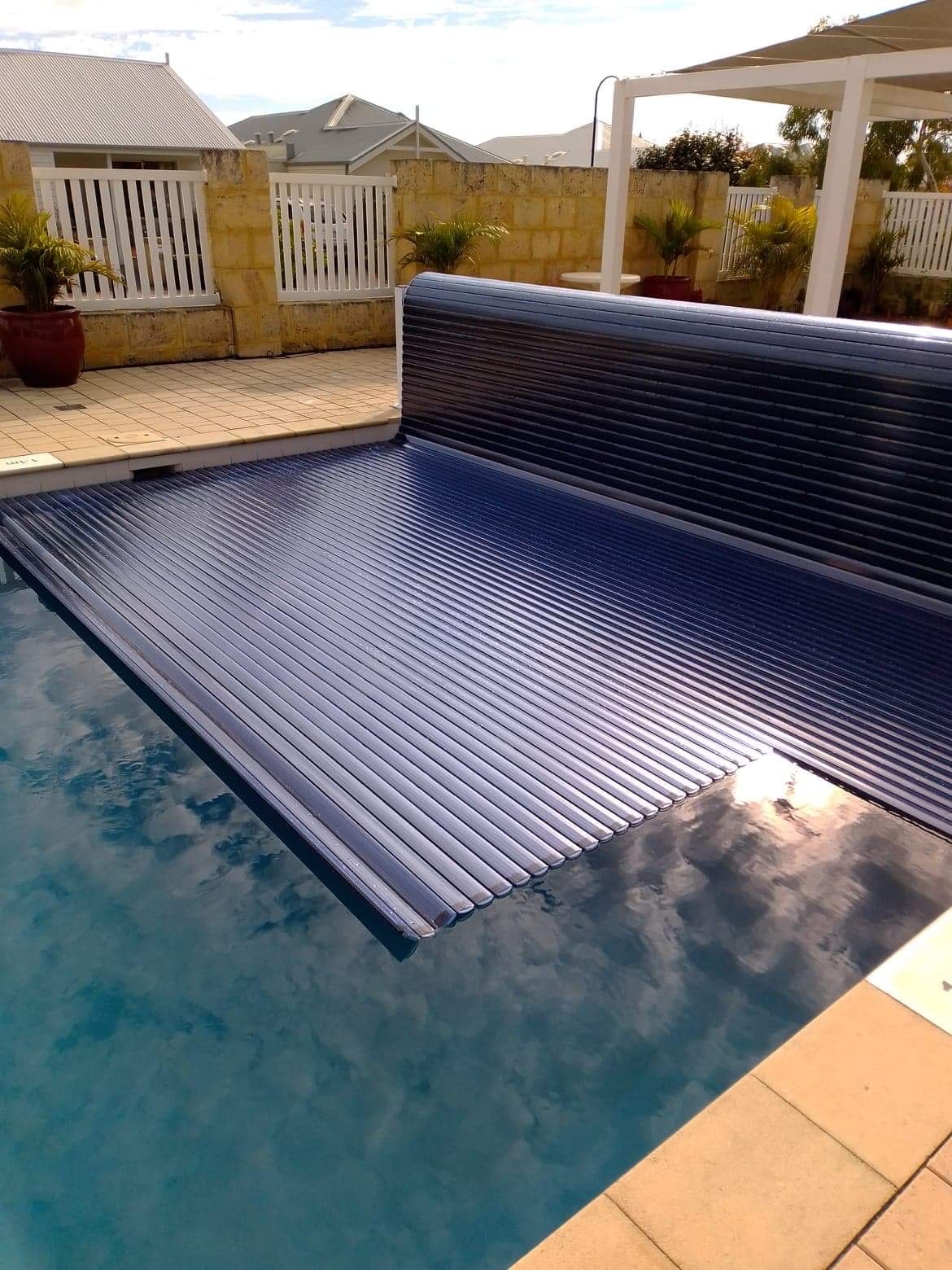 Aquaroll Rigid Slat automated pool cover on a pool